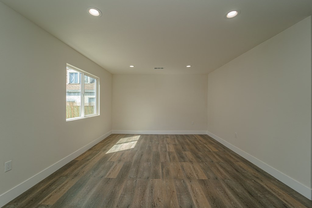 an empty room with wooden floors and a window