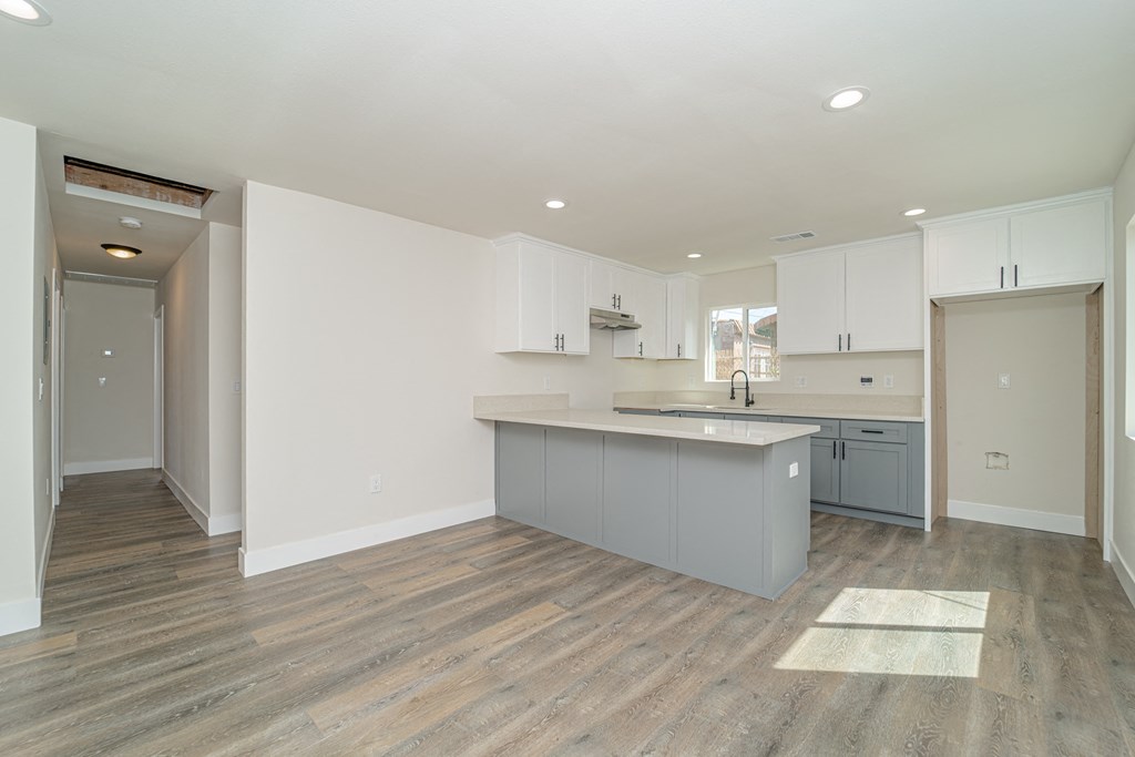 a renovated kitchen with white cabinets and a gray counter top