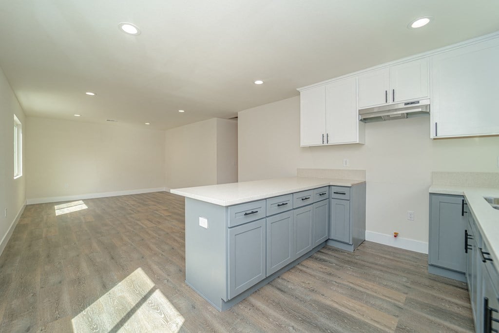 an empty kitchen with blue cabinets and a white counter top