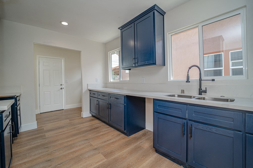a kitchen with blue cabinets and a sink and a faucet
