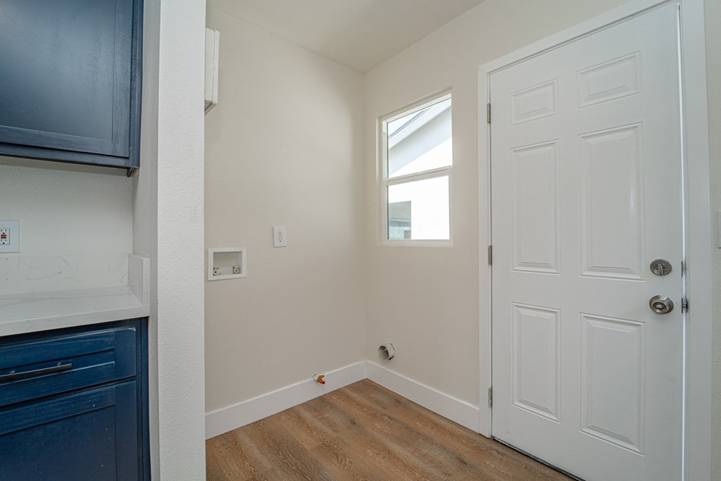 an empty kitchen with a white door and a window