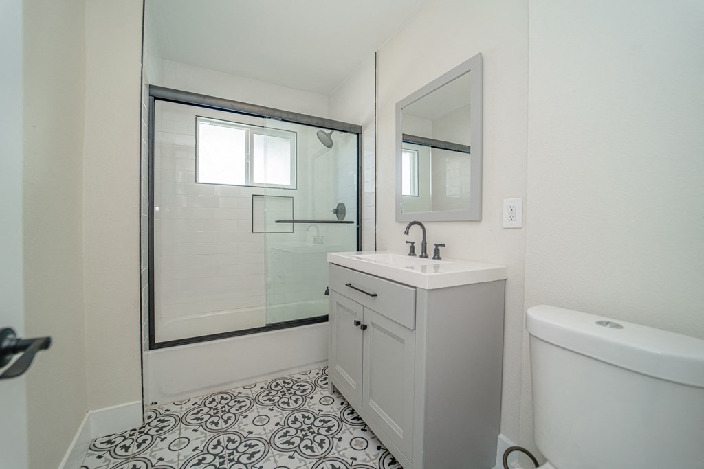 a white bathroom with a sink and a shower