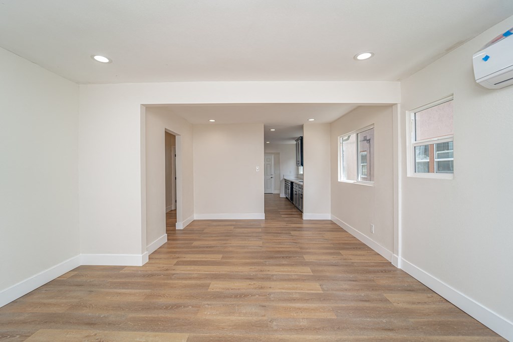 a long hallway with a wood floor and white walls