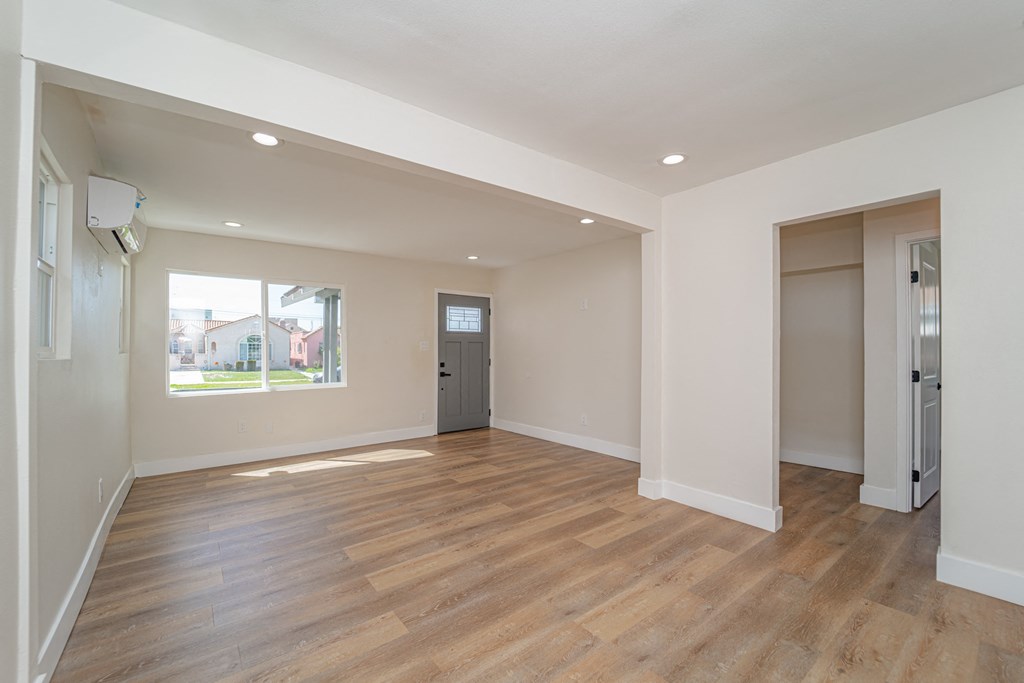 an empty living room with a window and a door