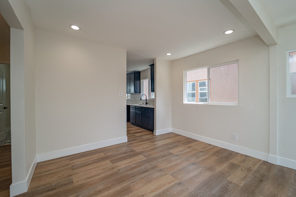 a kitchen and living room with wood floors and white walls