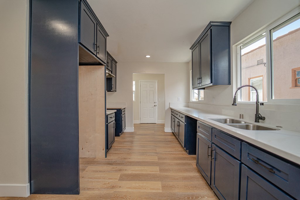 a large kitchen with blue cabinets and a large sink