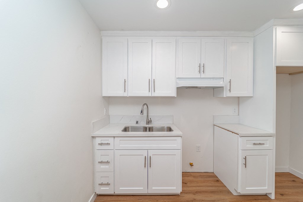 a kitchen with white cabinets and a sink