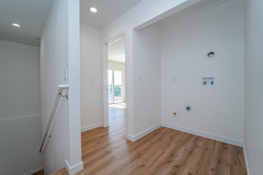 a living room with white walls and a wooden floor