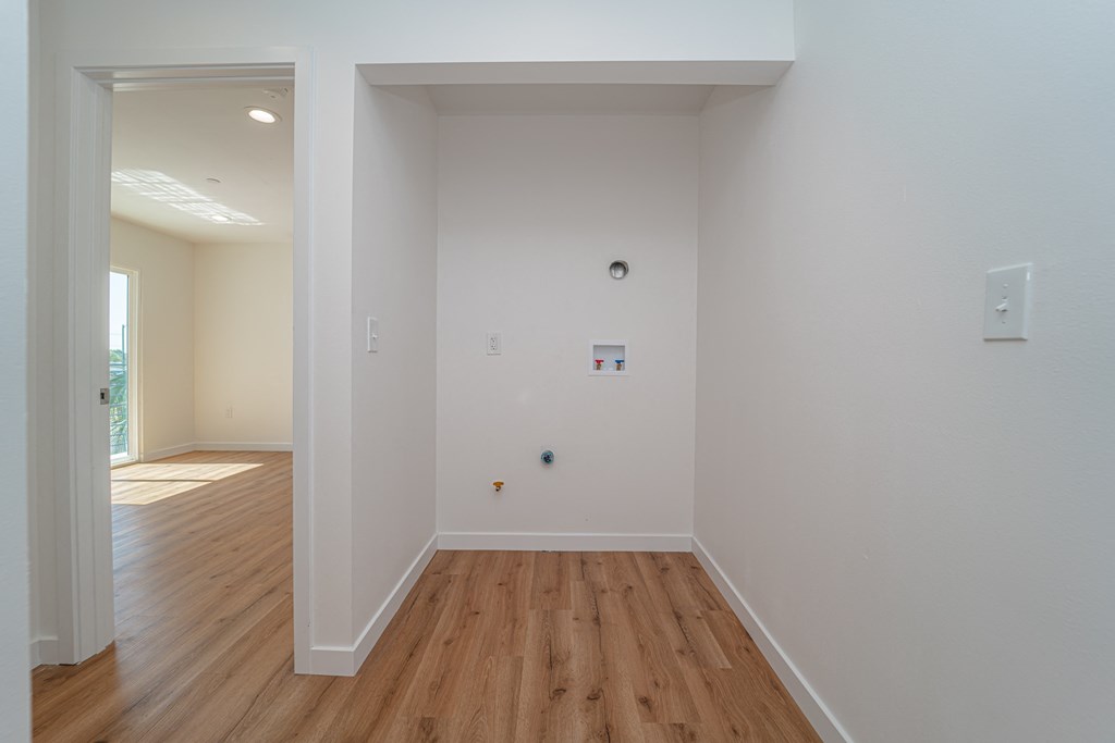 an empty room with white walls and wooden floors