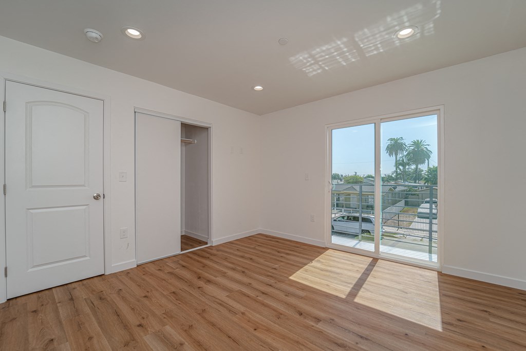 a living room with a large window and a door to a balcony