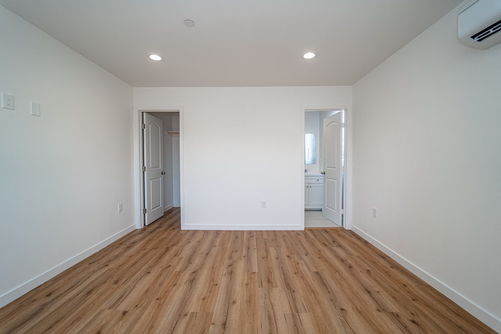 a living room with white walls and wood floors