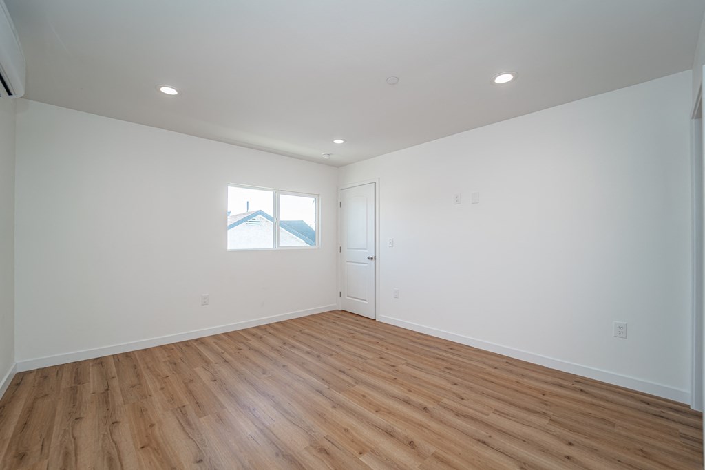 a living room with white walls and wood floors