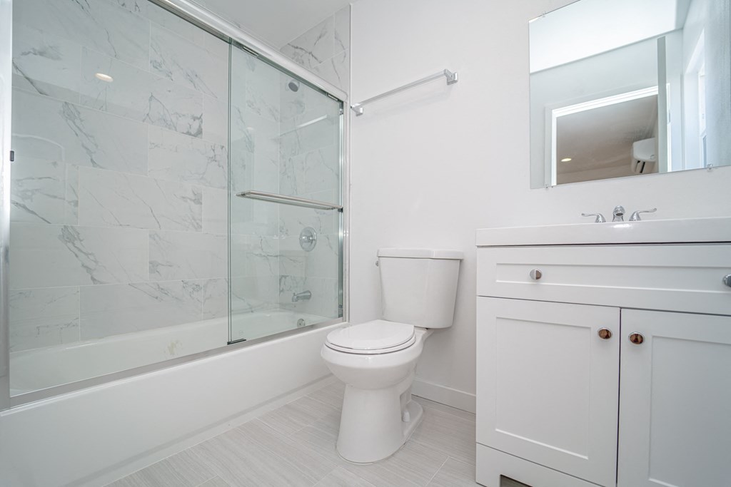 a white bathroom with a shower and a toilet