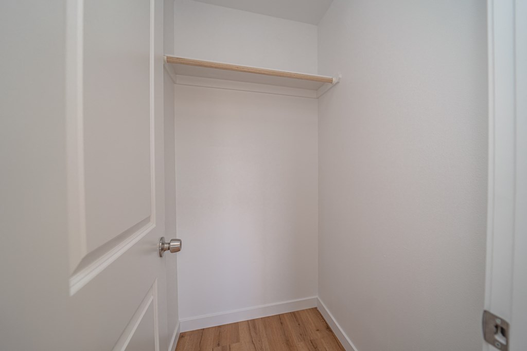 an empty room with a white door and a wooden floor