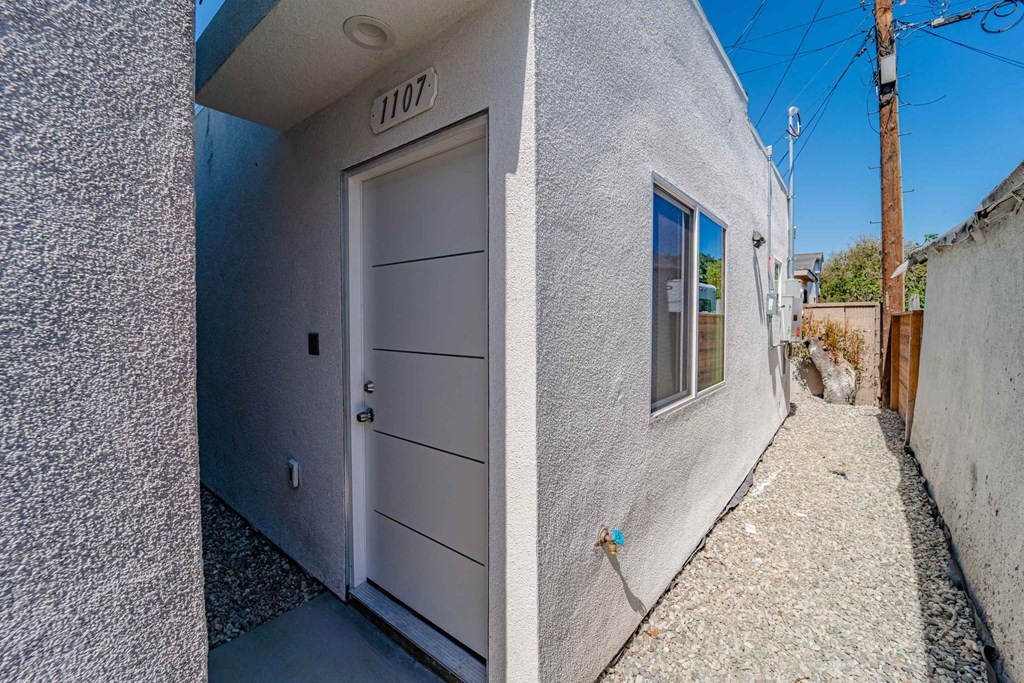 the front door of a building with a gray door and a window