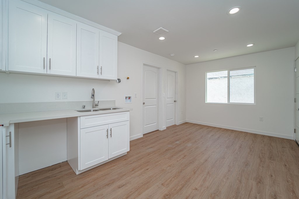 a kitchen with white cabinets and a sink and a counter
