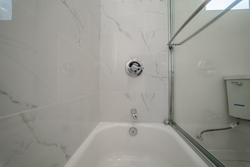 a white bathroom with a shower and a sink