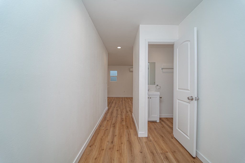 an empty room with a wooden floor and a white door