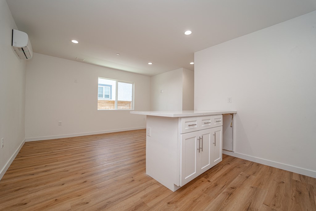 an empty kitchen with white cabinets and a white counter top