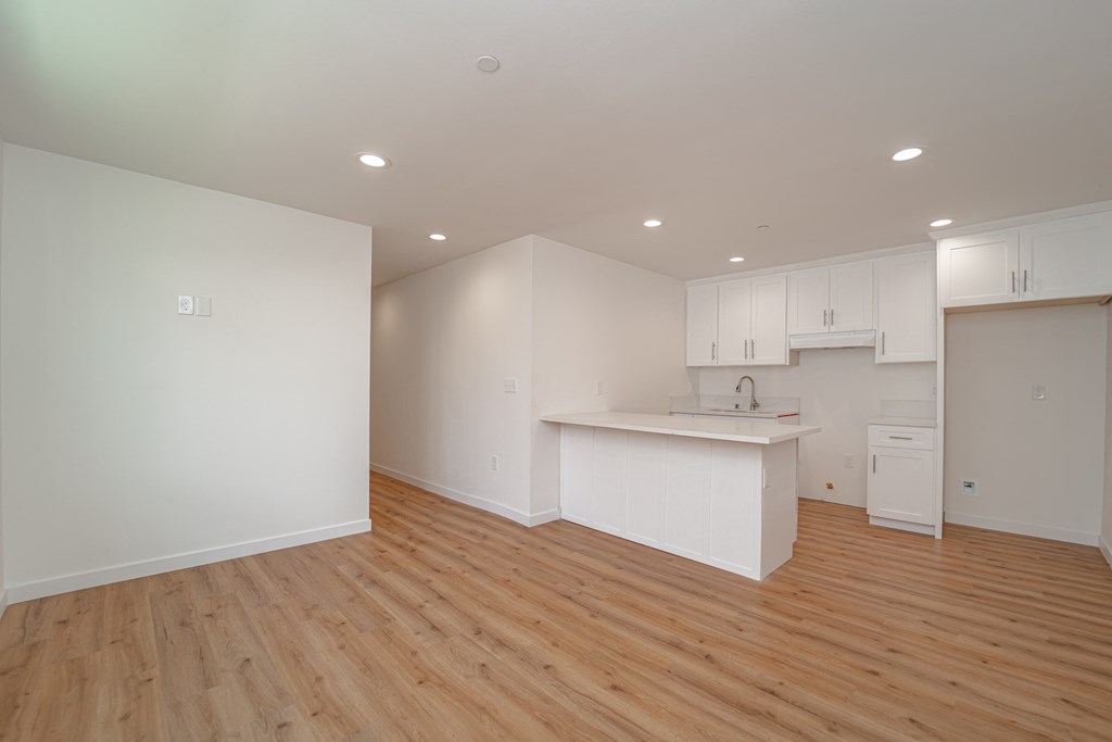 an empty kitchen with white cabinets and a white counter top