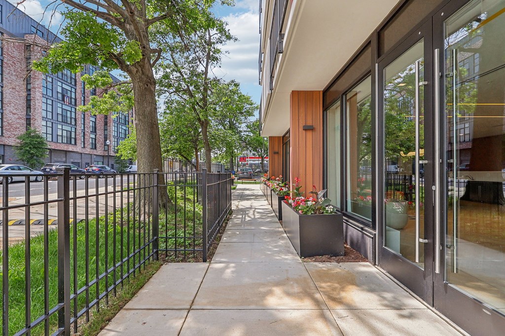 a sidewalk in front of a building with glass doors