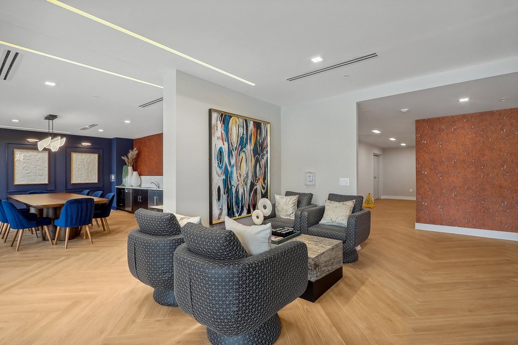 a living room with a couch and chairs and a dining room