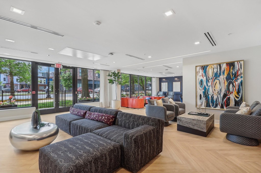 a living room with couches and chairs and large windows