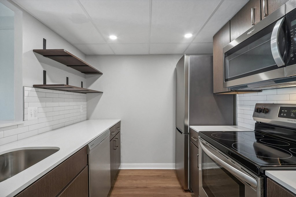 a renovated kitchen with stainless steel appliances and white counter tops