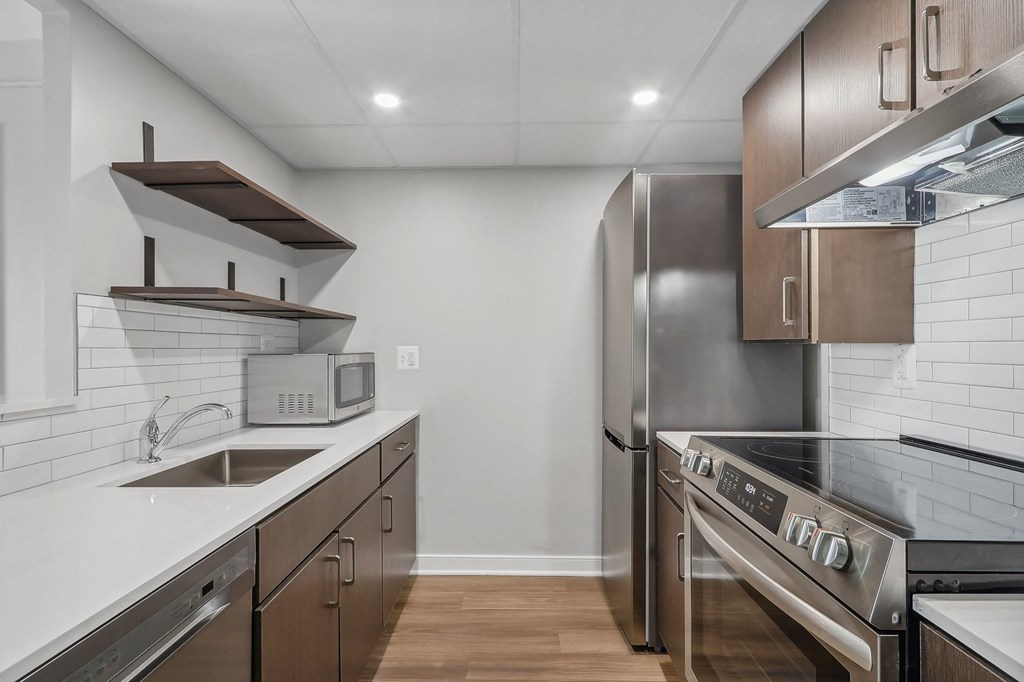 a modern kitchen with stainless steel appliances and white counter tops