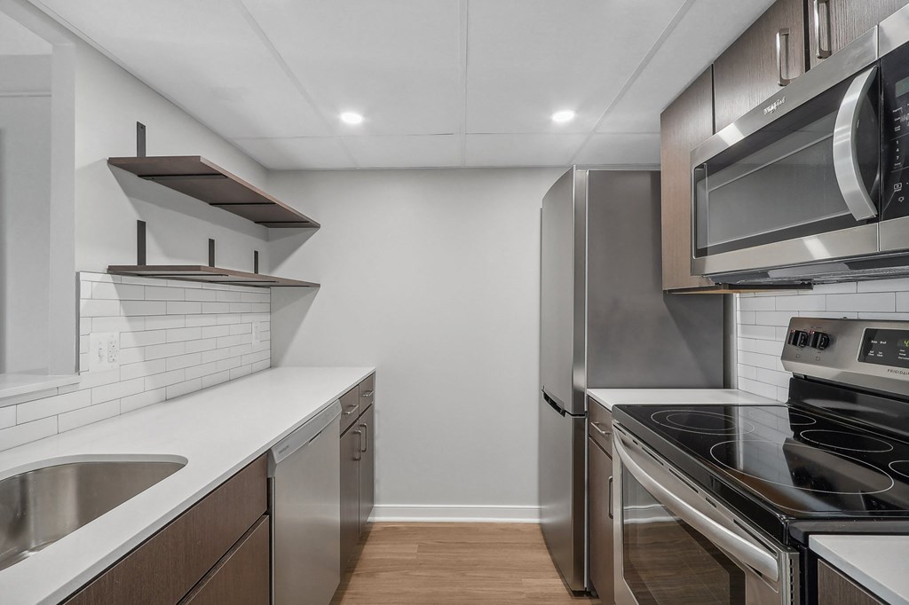 a renovated kitchen with stainless steel appliances and white cabinets