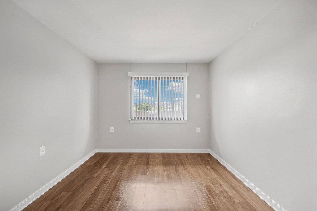 a spacious living room with hardwood floors and a window