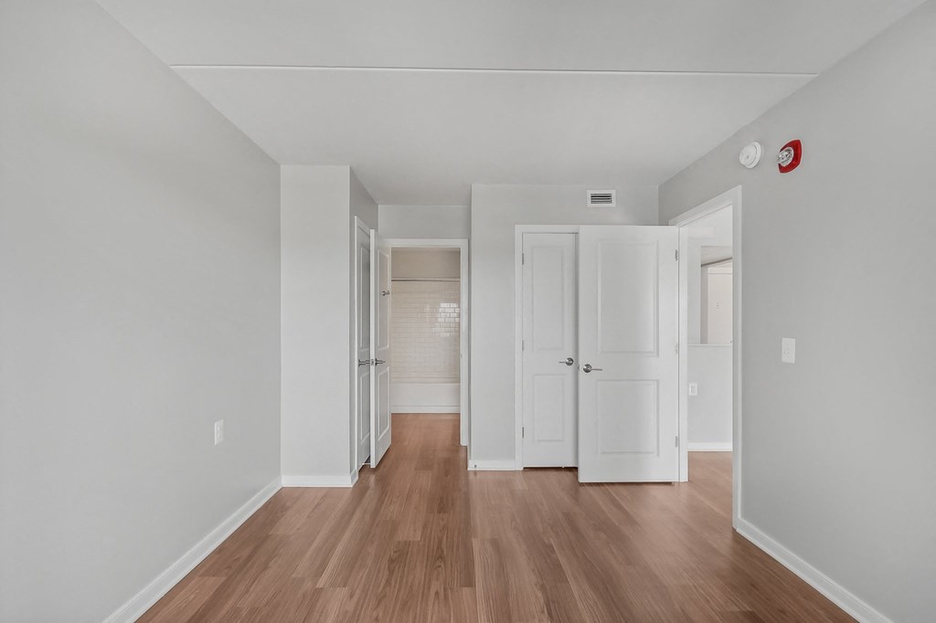 a renovated living room with white walls and wood floors