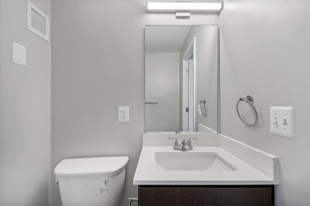 an empty bathroom with a sink toilet and mirror