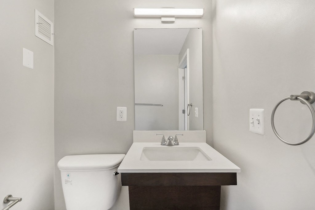 an empty bathroom with a toilet sink and mirror