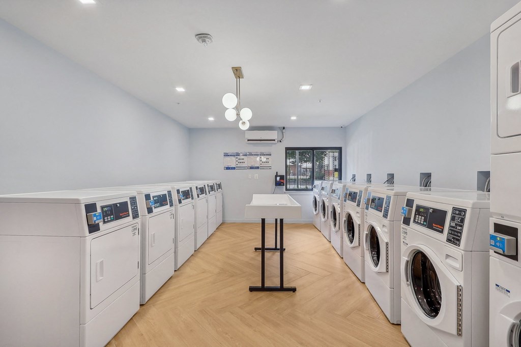 a washer and dryer room with a row of washing machines