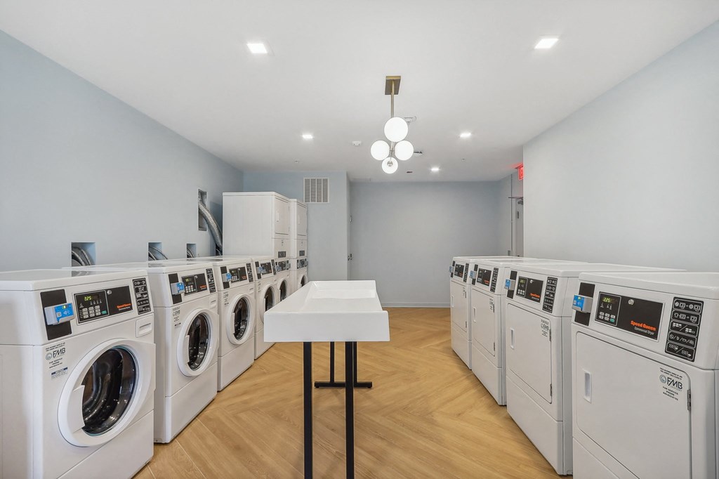 a laundry room filled with washers and dryers and a table