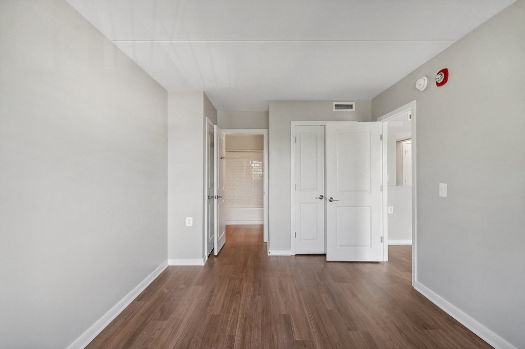 a renovated living room with white walls and wood floors
