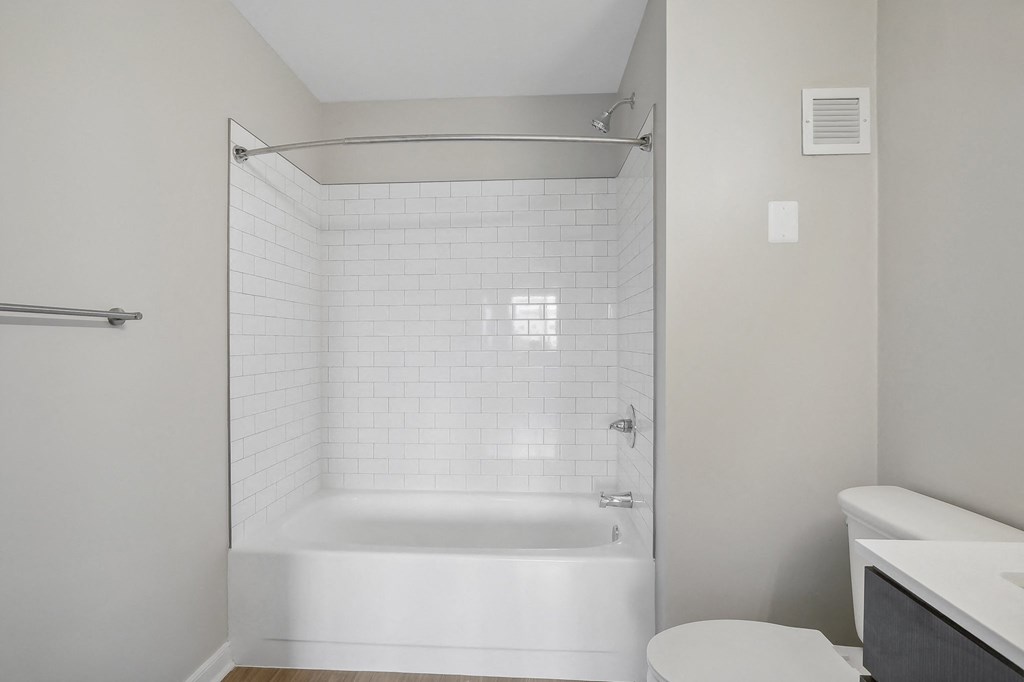 a white bathroom with a shower and a toilet
