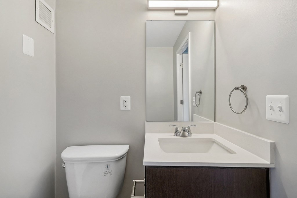 an empty bathroom with a toilet sink and mirror