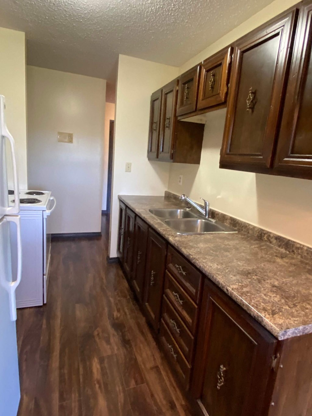A kitchen with brown cabinets and a granite countertop.