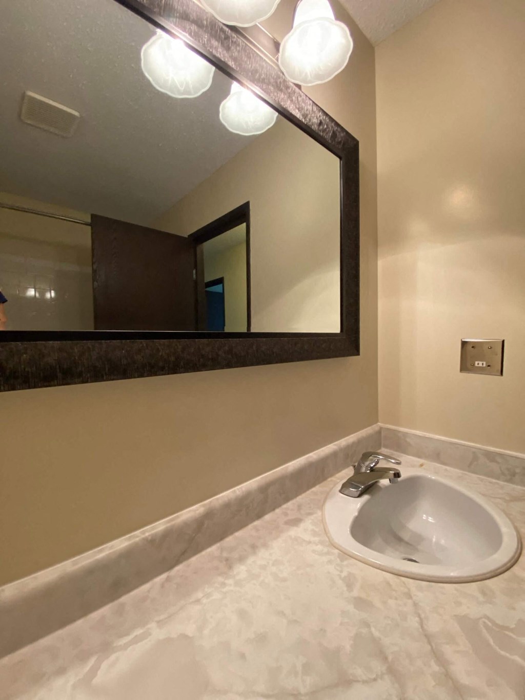 A bathroom with a sink and mirror.