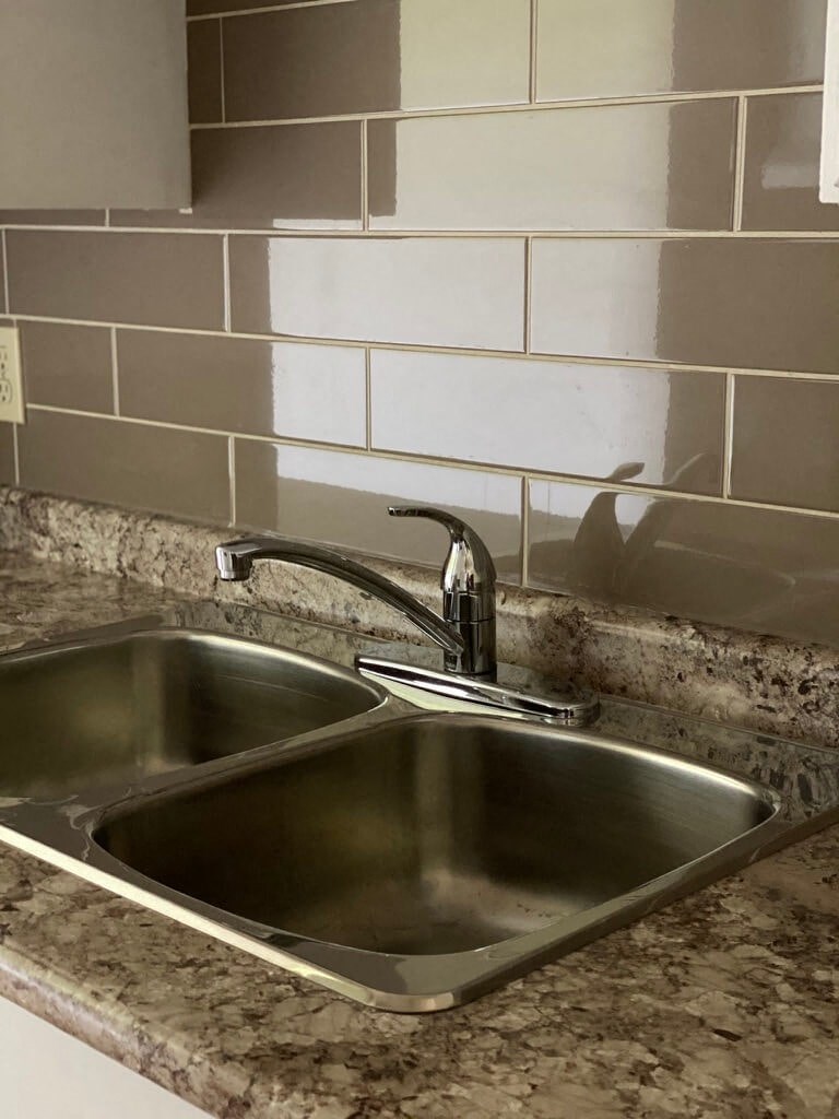 a stainless steel sink in a granite counter top