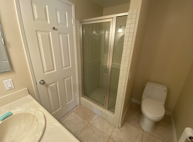 a bathroom with a shower and a sink and a toilet