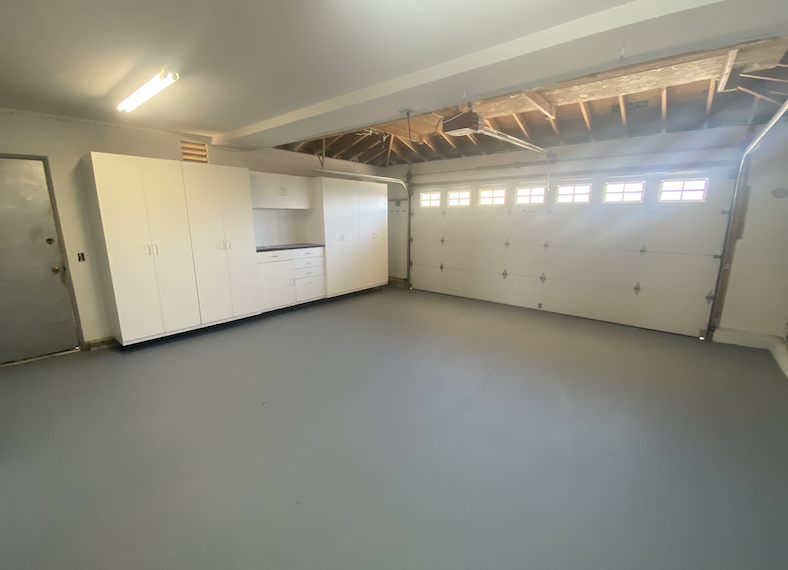 a garage with white cabinets and white doors