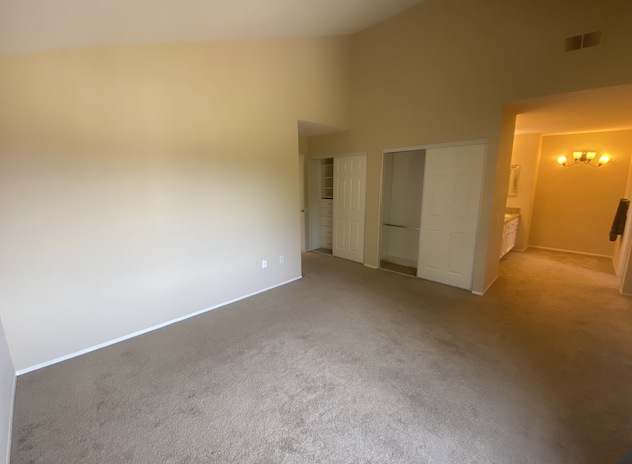 an empty living room with white walls and carpet