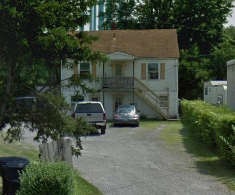 a white house with a car parked in the driveway