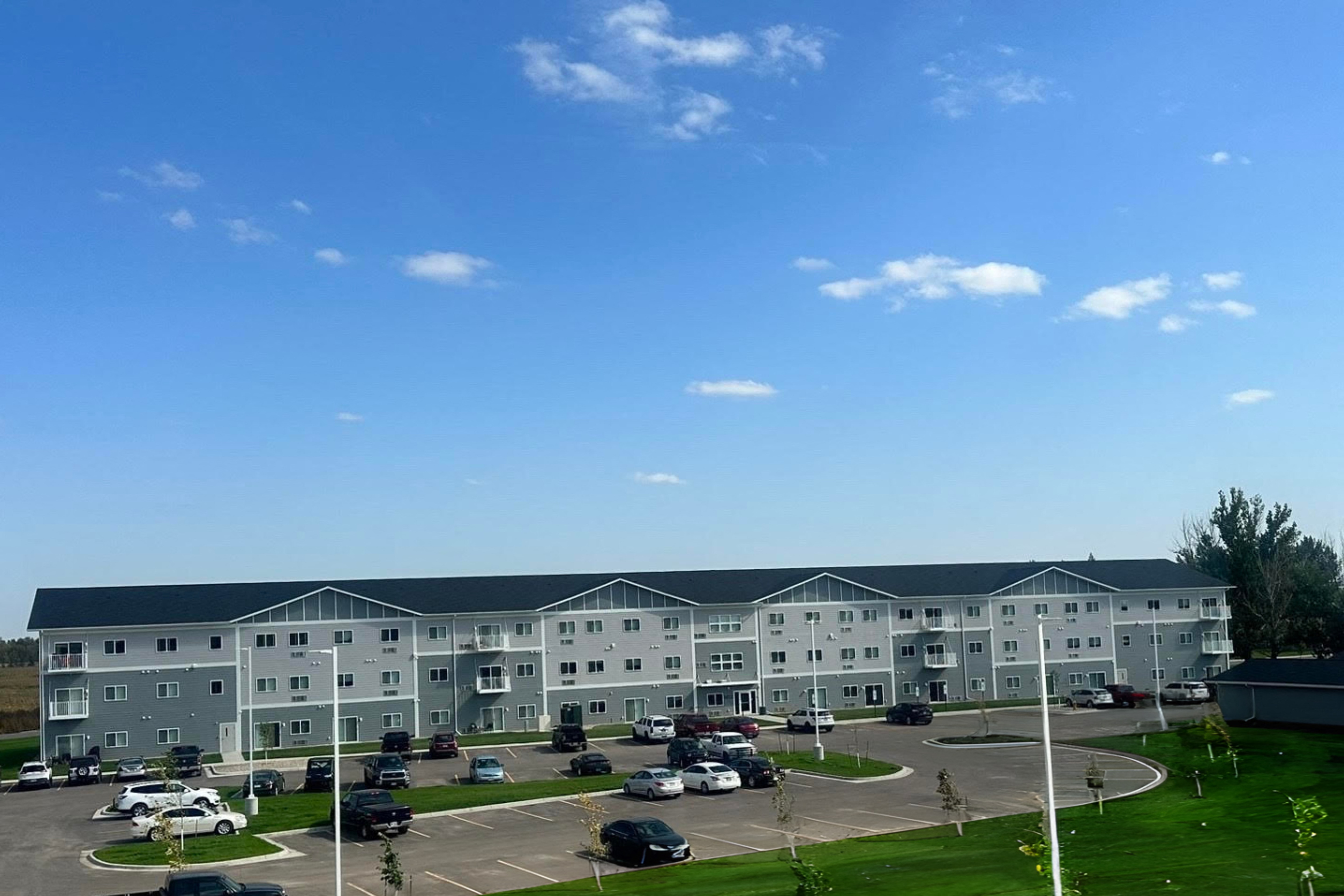 A large white building with a parking lot in front.