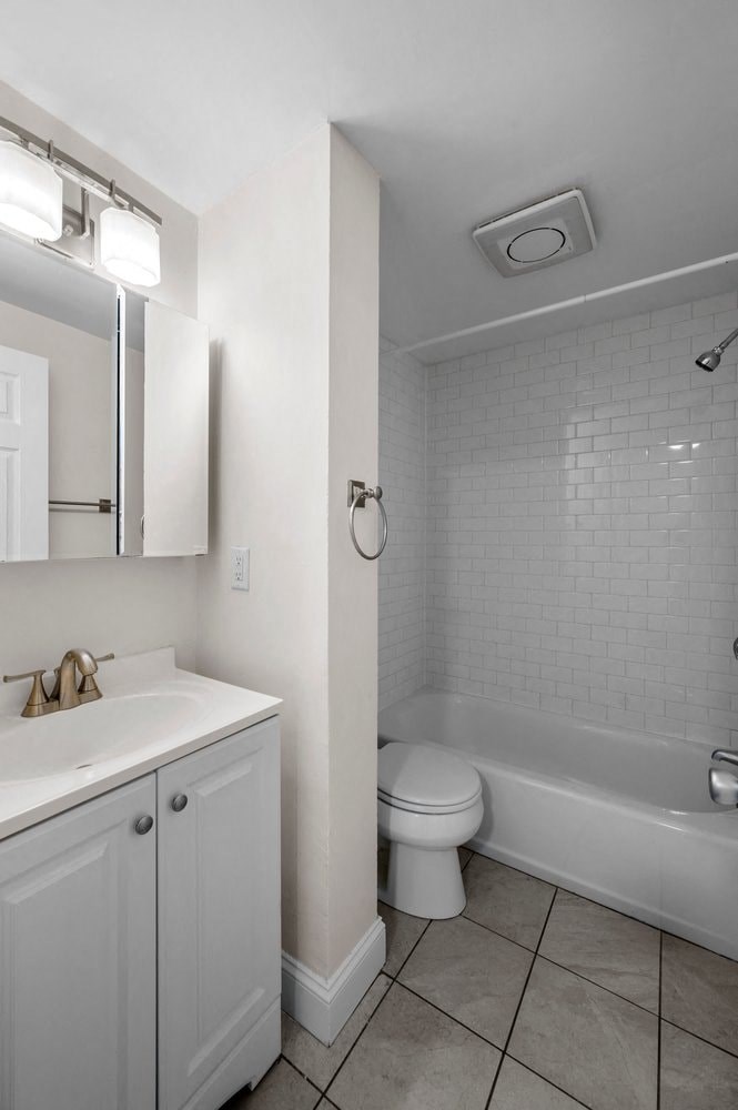 a white bathroom with a toilet and a sink