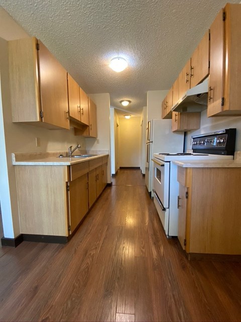 A kitchen with wooden cabinets and a white refrigerator.