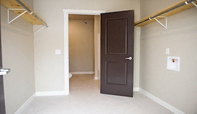 a empty room with a brown door and a closet
